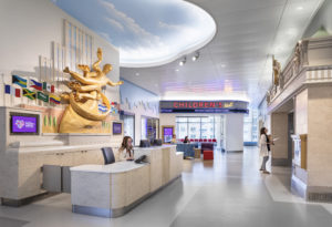 Photograph of the interior of NYU Hassenfeld Children's Hospital showing a reception desk and a reproduction of the Prometheus statue at Rockefeller Center
