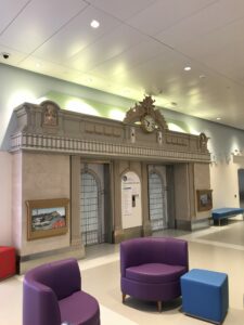 Photograph of the interior of NYU Hassenfeld Children's Hospital showing an elevator bank that looks like Grand Central Terminal